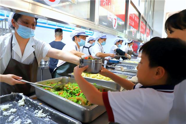 图为浠水县第四实验小学学生利用人脸识别系统排队取餐